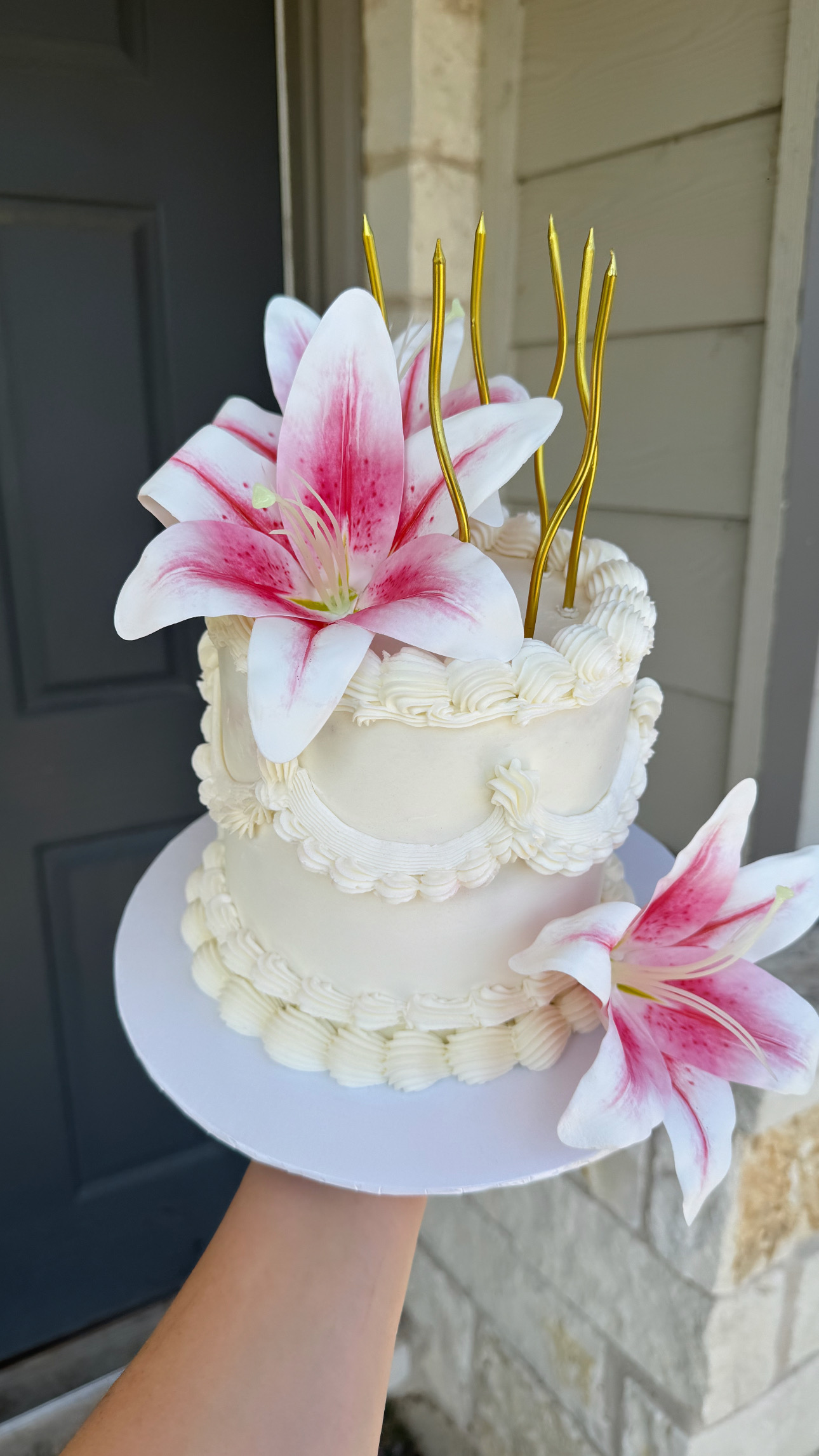 White cake decorated with pink lilies